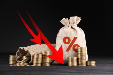Image of Burlap bag with percent sign, arrows and coins against black background