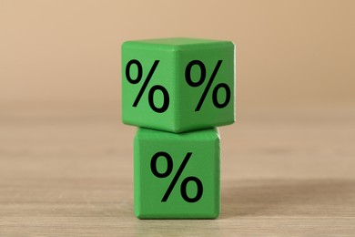 Image of Green cubes with percent signs on wooden table