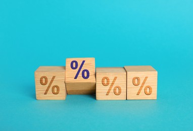 Image of Wooden cubes with percents signs on light blue background