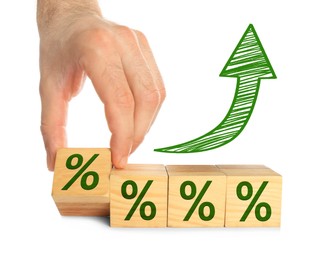 Image of Man holding wooden cube with percent sign against white background, closeup