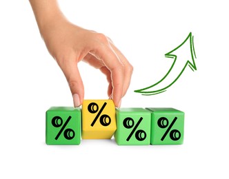 Image of Woman holding yellow cube with percent sign among green ones on white background, closeup