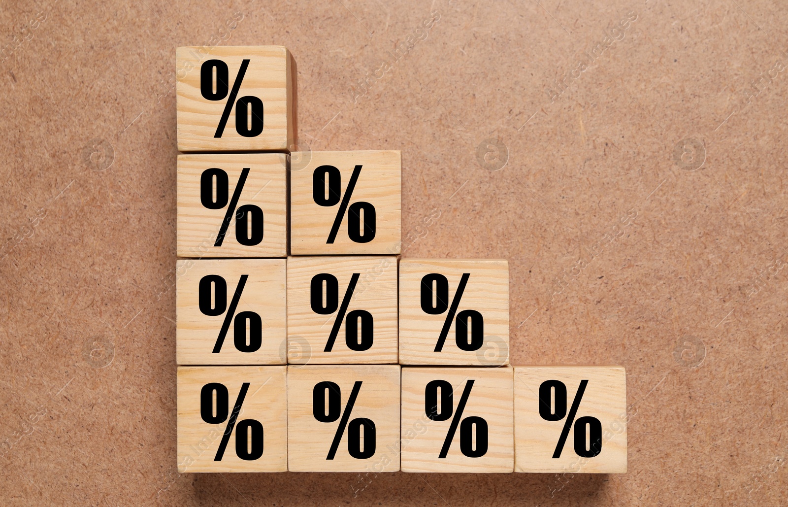 Image of Wooden cubes with percent signs on brown textured background, top view