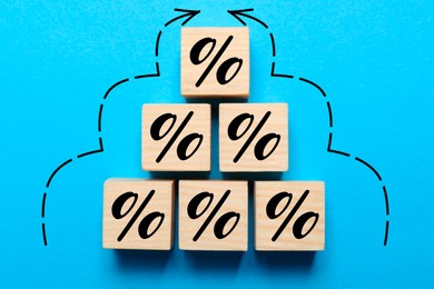 Image of Wooden cubes with percent signs and arrows on blue background, top view