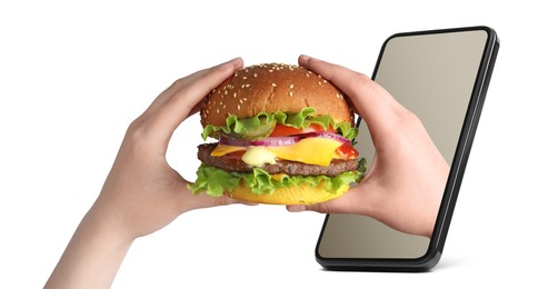Image of Food ordering and delivery service. Woman eating burger with one hand sticking out of mobile phone display against white background, closeup