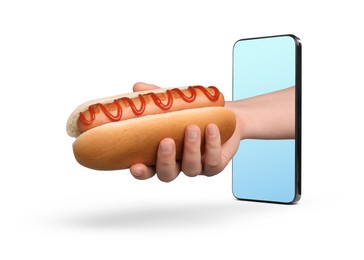 Image of Food ordering and delivery service. Woman's hand with tasty hot dog, sticking out of mobile phone display against white background, closeup