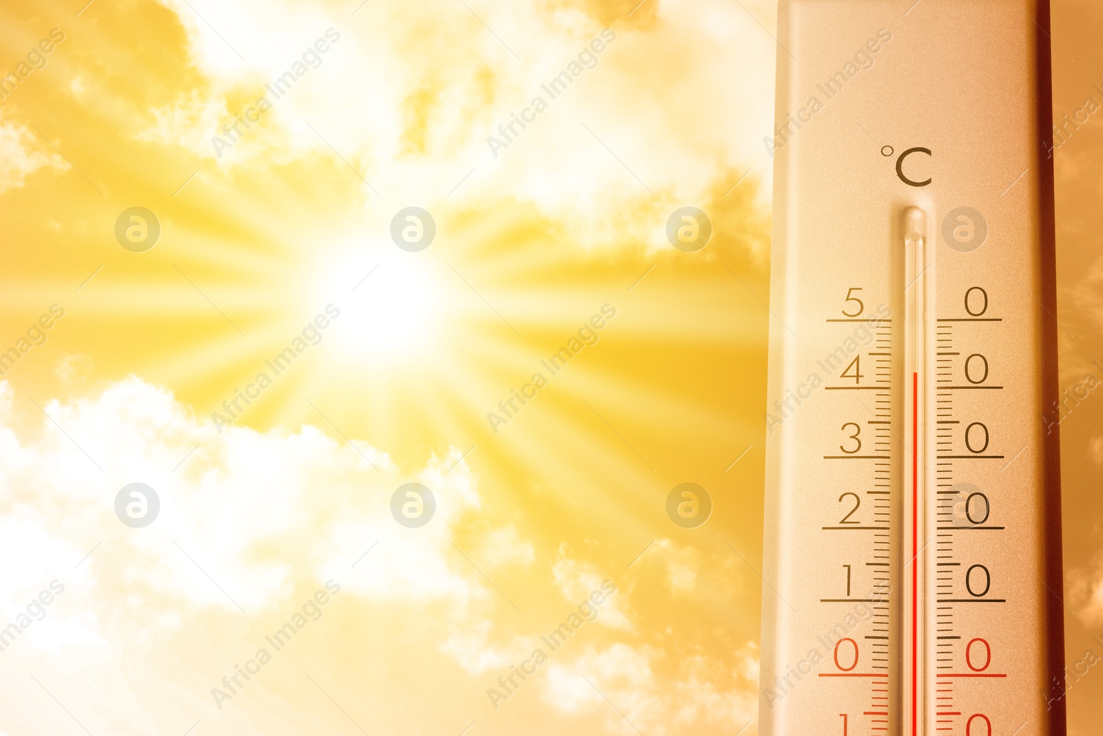 Image of High temperature on thermometer against orange sky on sunny day. Hot summer weather