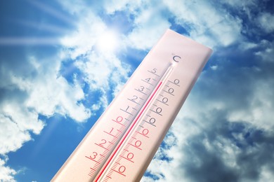 Image of Extremely high temperature on thermometer against blue sky on sunny day. Summer weather