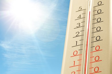 Image of Extremely high temperature on thermometer against blue sky on sunny day. Summer weather