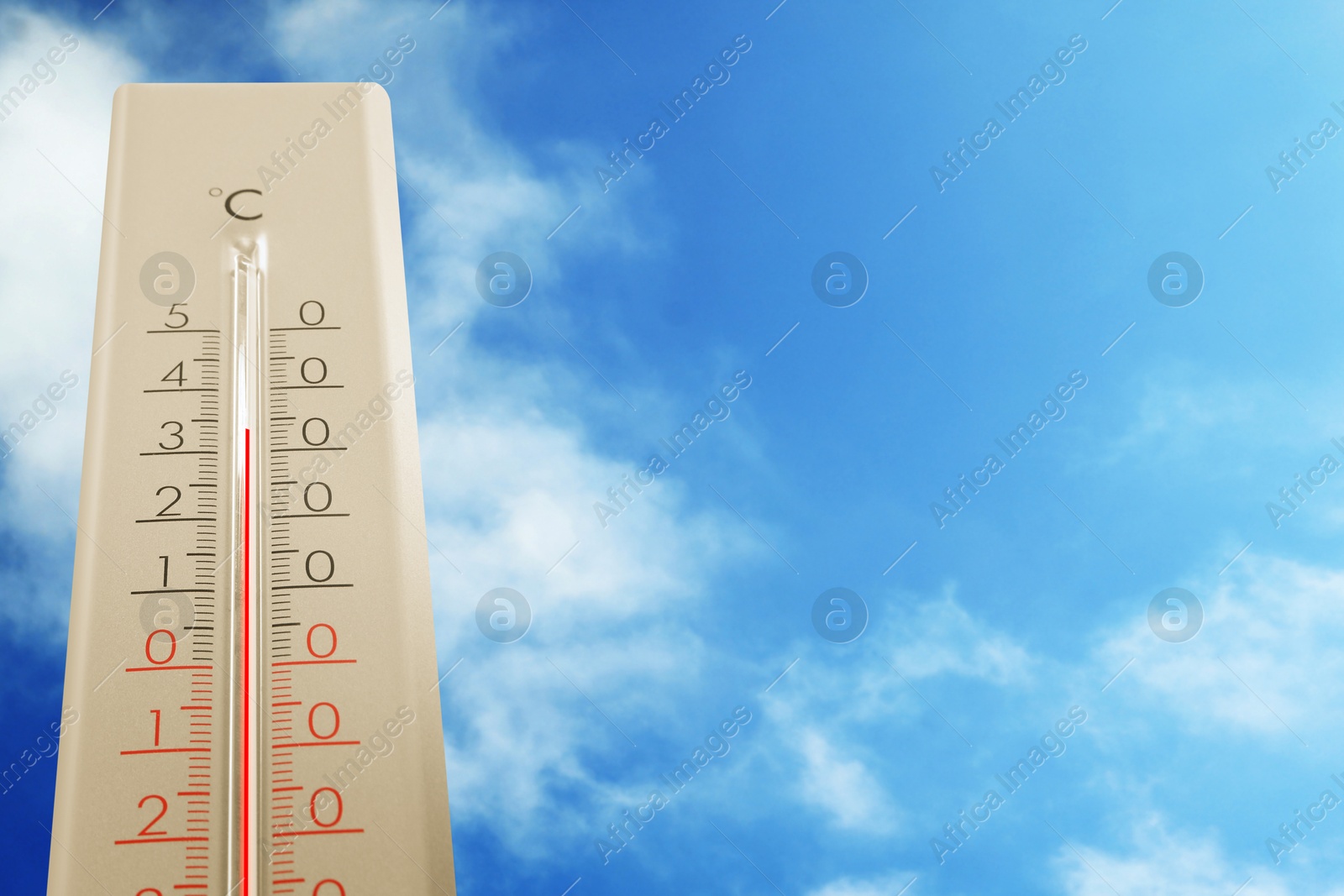 Image of High temperature on thermometer against blue sky on sunny day. Summer weather