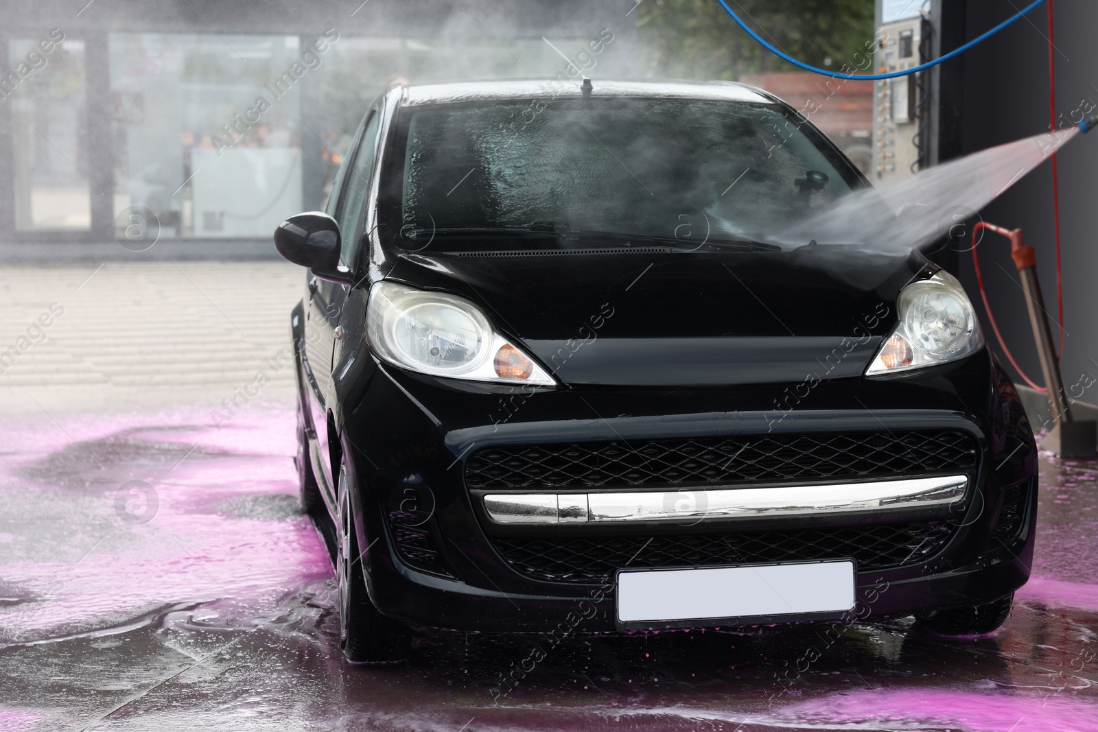 Washing auto with high pressure water jet at car wash, closeup Photo of Washing auto with high pressure water jet at car wash, closeup