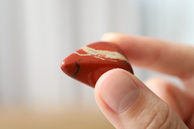 Photo of Woman with healing stone on blurred background, closeup
