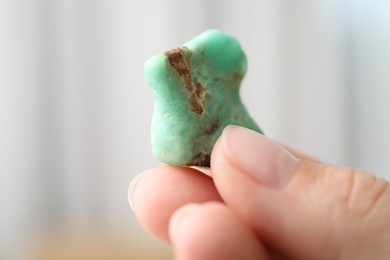 Photo of Woman with healing stone on blurred background, closeup