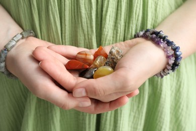 Photo of Woman with different beautiful healing stones, closeup