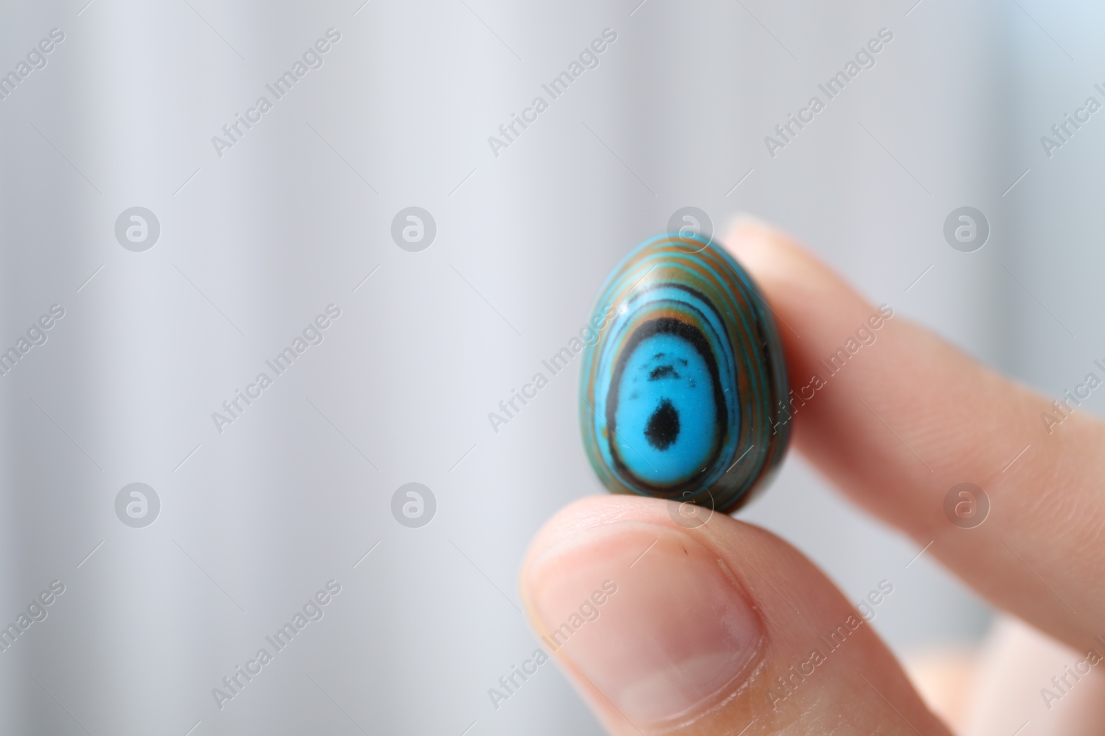 Woman with healing stone on blurred background, closeup. Space for text Photo of Woman with healing stone on blurred background, closeup. Space for text