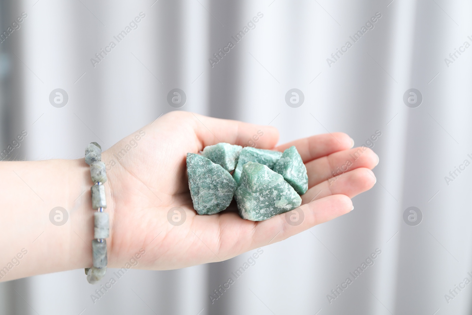 Woman with healing stones on blurred background, closeup Photo of Woman with healing stones on blurred background, closeup