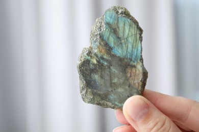 Photo of Woman with healing stone on blurred background, closeup