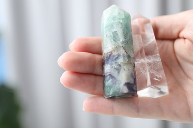 Photo of Woman with healing crystals on blurred background, closeup