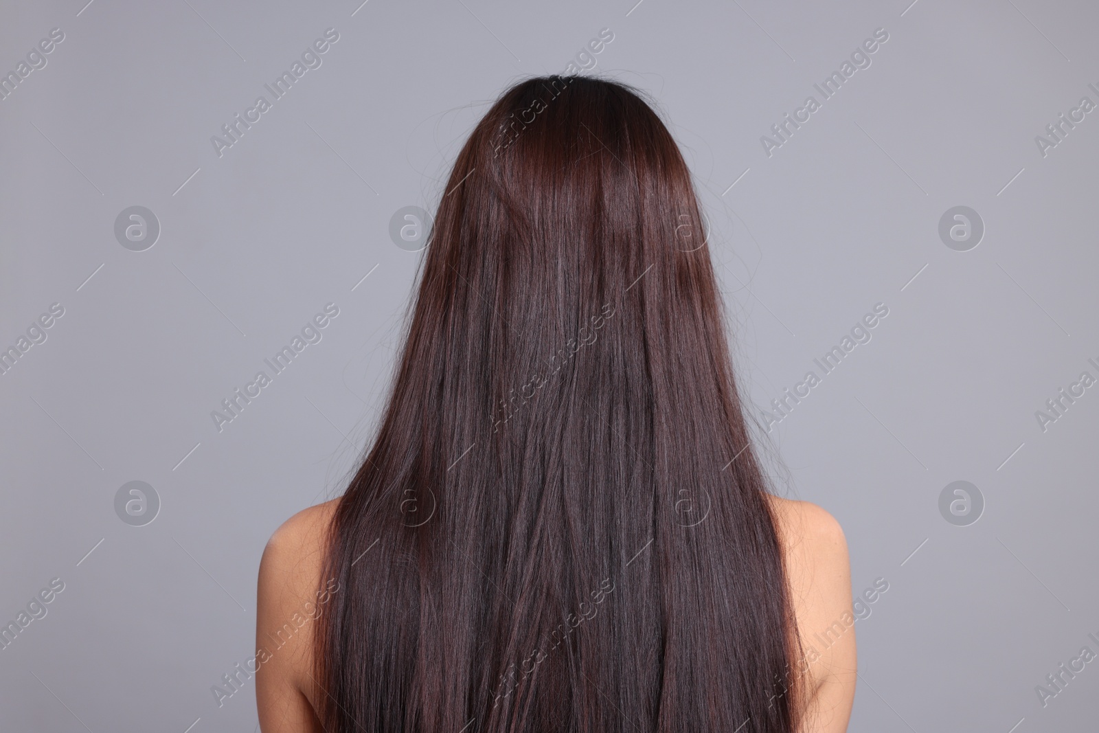 Woman with damaged hair before lamination procedure on light grey background, back view Photo of Woman with damaged hair before lamination procedure on light grey background, back view