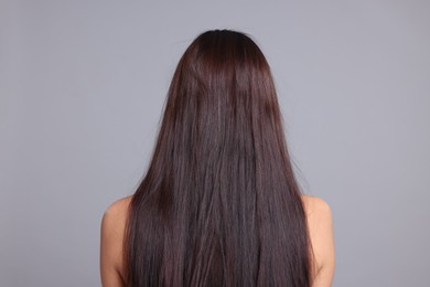 Photo of Woman with damaged hair before lamination procedure on light grey background, back view