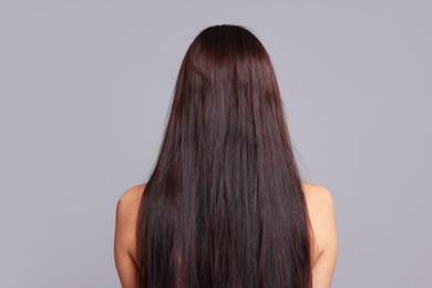 Photo of Woman with damaged hair before lamination procedure on light grey background, back view
