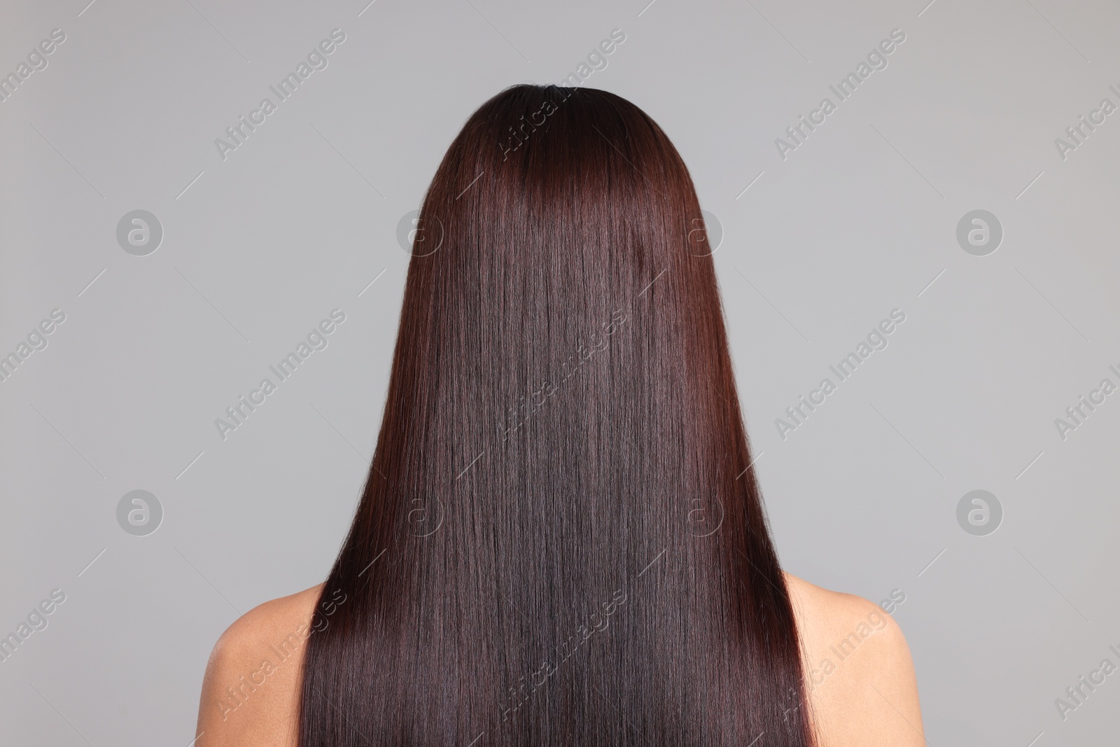 Photo of Woman with beautiful smooth hair after lamination procedure on light grey background, back view