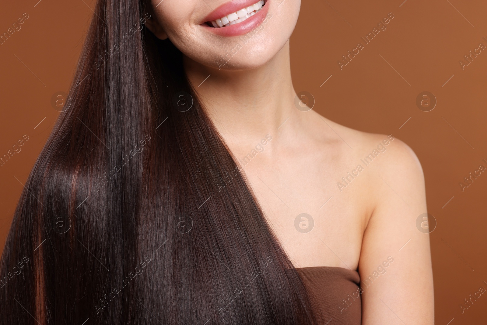 Woman with beautiful smooth hair after lamination procedure on brown background, closeup Photo of Woman with beautiful smooth hair after lamination procedure on brown background, closeup