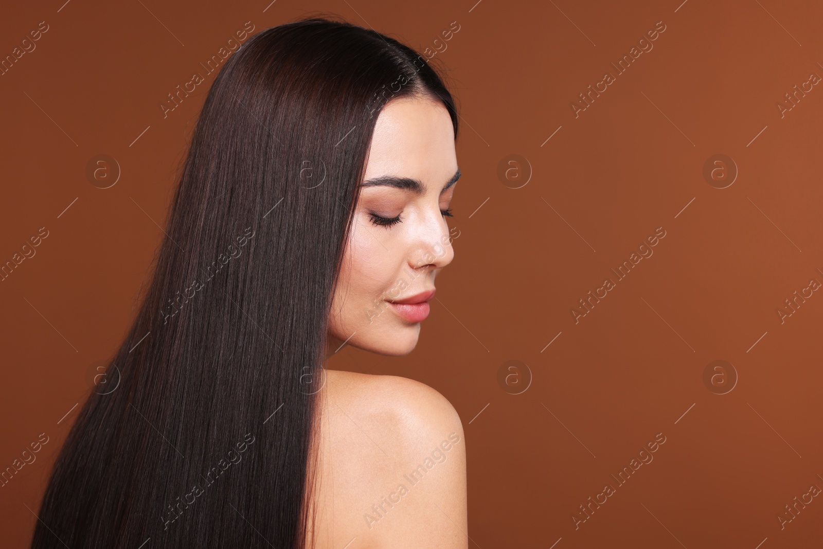 Photo of Woman with beautiful smooth hair after lamination procedure on brown background, space for text