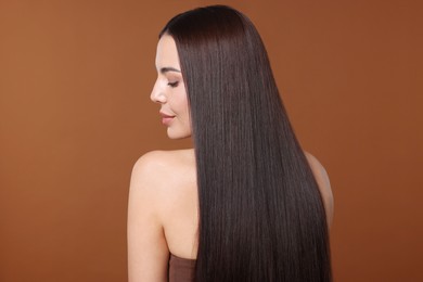 Photo of Woman with beautiful smooth hair after lamination procedure on brown background