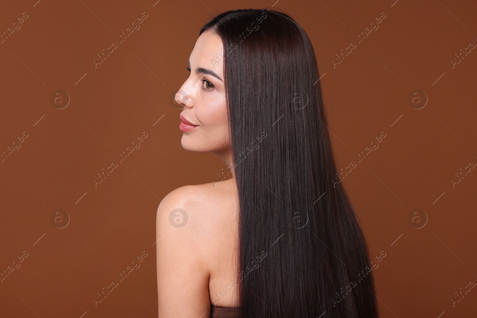 Woman with beautiful smooth hair after lamination procedure on brown background Photo of Woman with beautiful smooth hair after lamination procedure on brown background