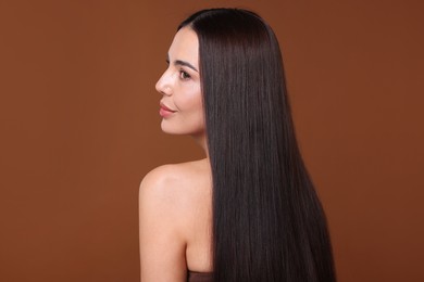 Photo of Woman with beautiful smooth hair after lamination procedure on brown background