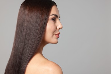 Photo of Woman with beautiful smooth hair after lamination procedure on light grey background, space for text