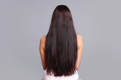 Photo of Woman with damaged hair before lamination procedure on light grey background, back view