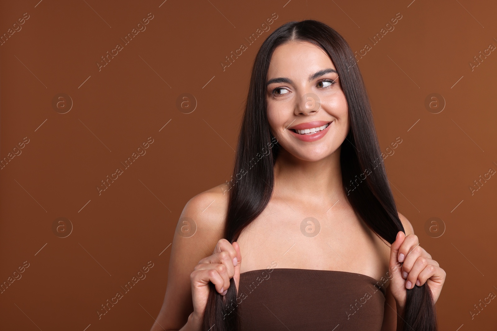 Woman with beautiful smooth hair after lamination procedure on brown background, space for text Photo of Woman with beautiful smooth hair after lamination procedure on brown background, space for text