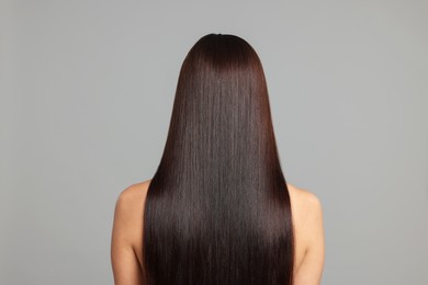Photo of Woman with beautiful smooth hair after lamination procedure on light grey background, back view