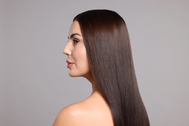Photo of Woman with beautiful smooth hair after lamination procedure on light grey background