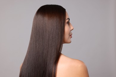 Photo of Woman with beautiful smooth hair after lamination procedure on light grey background
