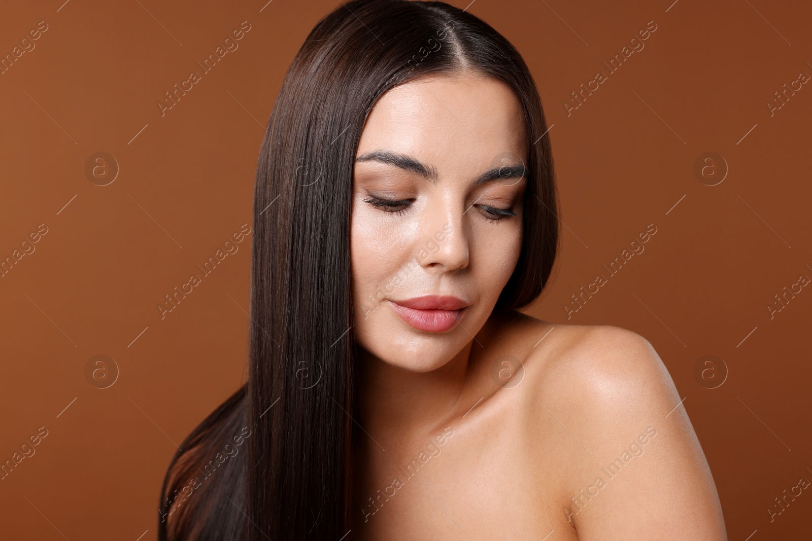 Photo of Woman with beautiful smooth hair after lamination procedure on brown background