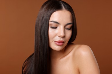 Photo of Woman with beautiful smooth hair after lamination procedure on brown background