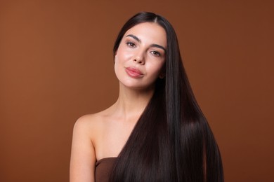 Photo of Woman with beautiful smooth hair after lamination procedure on brown background