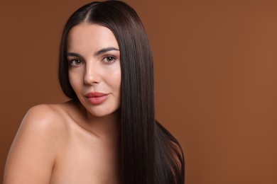 Photo of Woman with beautiful smooth hair after lamination procedure on brown background, space for text