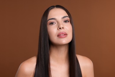 Photo of Woman with beautiful smooth hair after lamination procedure on brown background