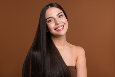 Photo of Woman with beautiful smooth hair after lamination procedure on brown background