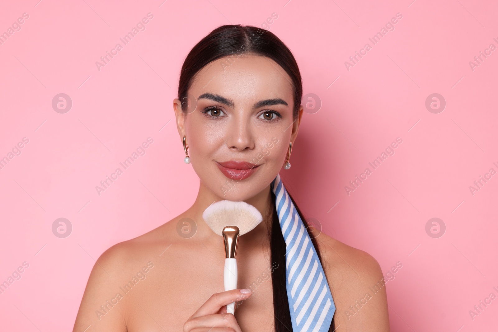 Photo of Beautiful woman with makeup brush on pink background