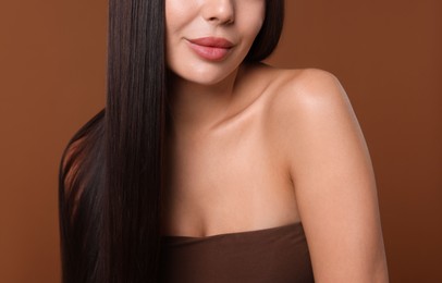 Photo of Woman with beautiful smooth hair after lamination procedure on brown background, closeup