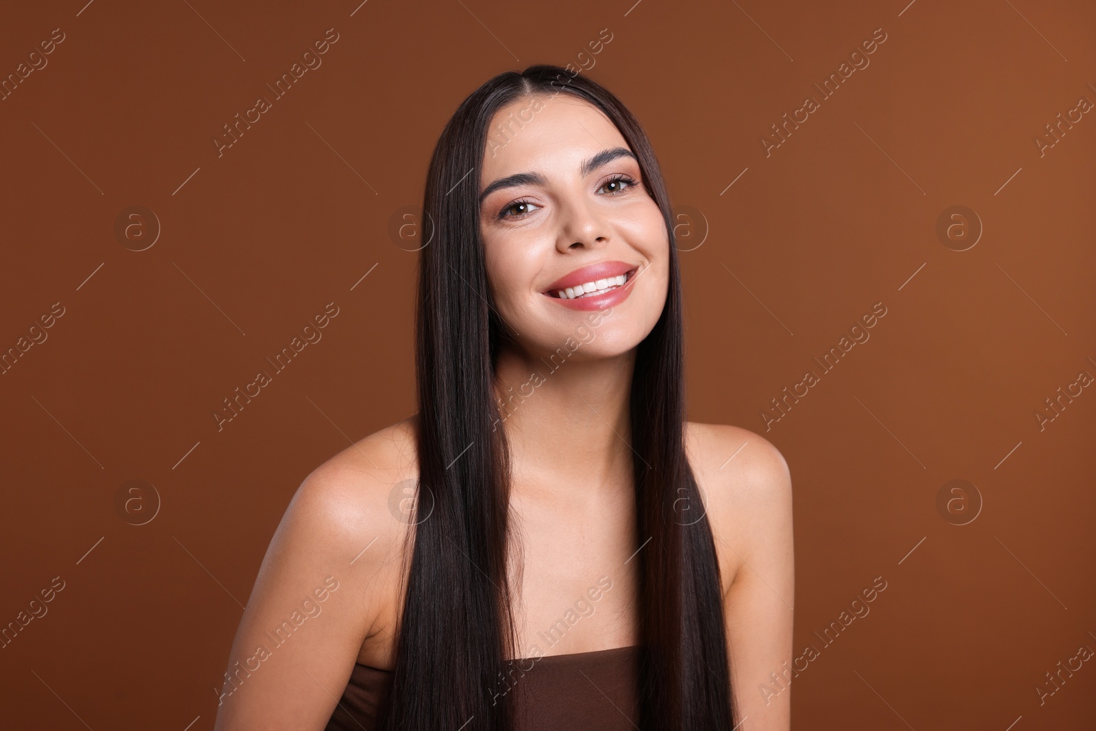 Photo of Woman with beautiful smooth hair after lamination procedure on brown background