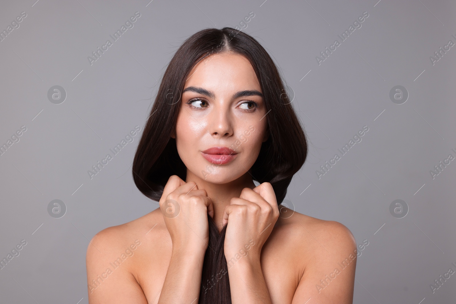 Photo of Woman with beautiful smooth hair after lamination procedure on light grey background