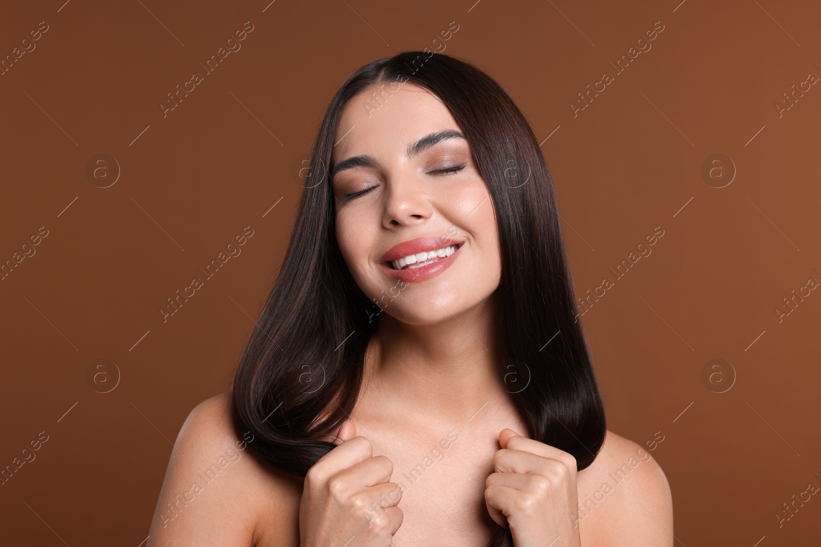 Photo of Woman with beautiful smooth hair after lamination procedure on brown background