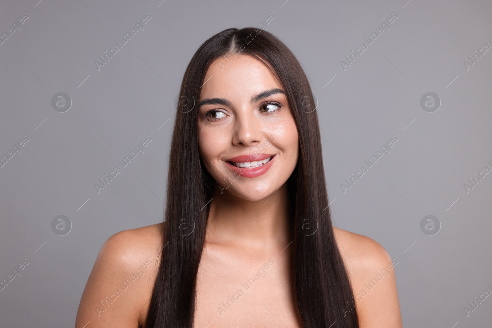 Woman with beautiful smooth hair after lamination procedure on light grey background Photo of Woman with beautiful smooth hair after lamination procedure on light grey background