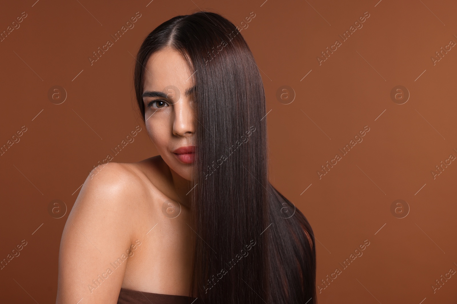 Woman with beautiful smooth hair after lamination procedure on brown background, space for text Photo of Woman with beautiful smooth hair after lamination procedure on brown background, space for text