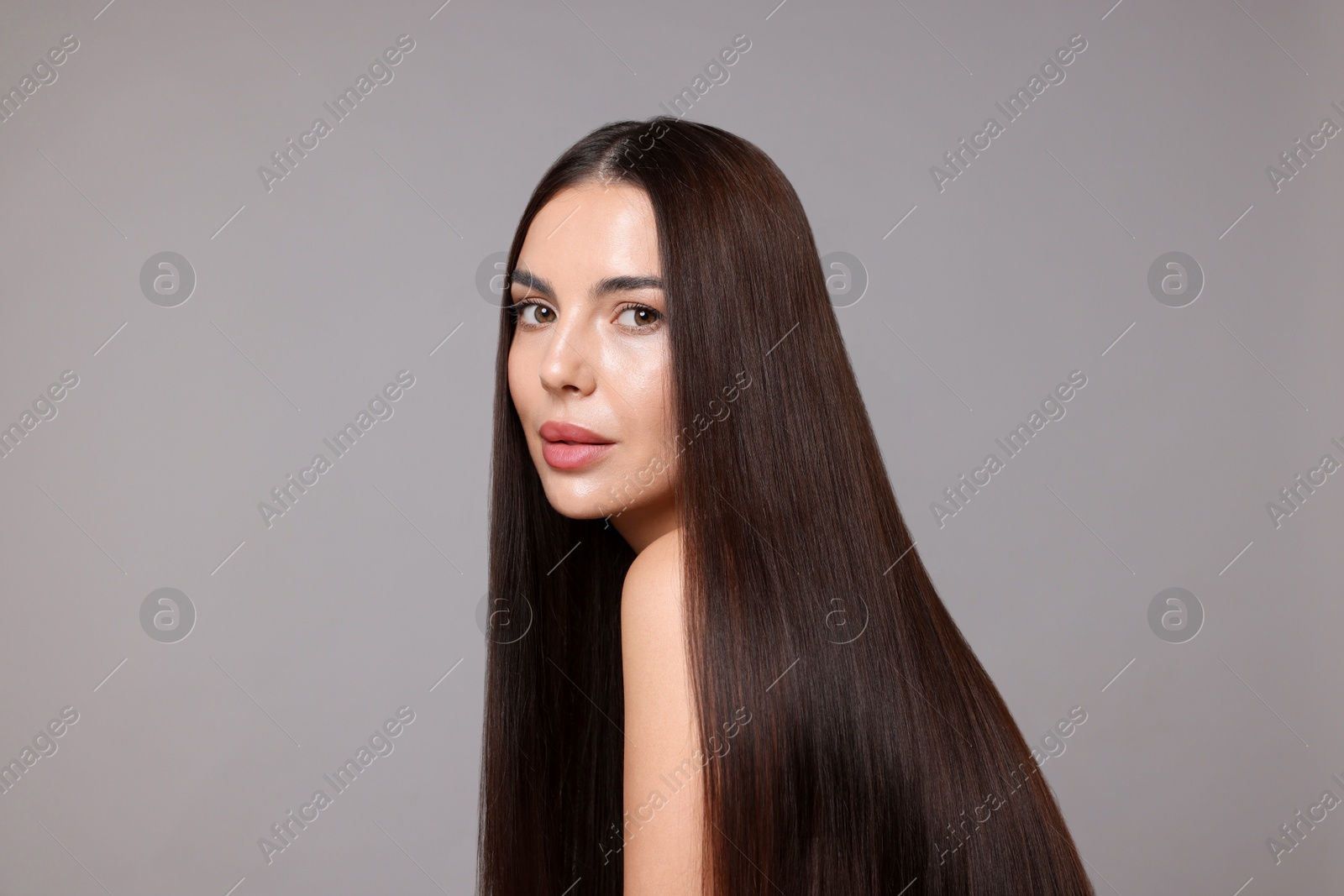 Woman with beautiful smooth hair after lamination procedure on light grey background Photo of Woman with beautiful smooth hair after lamination procedure on light grey background